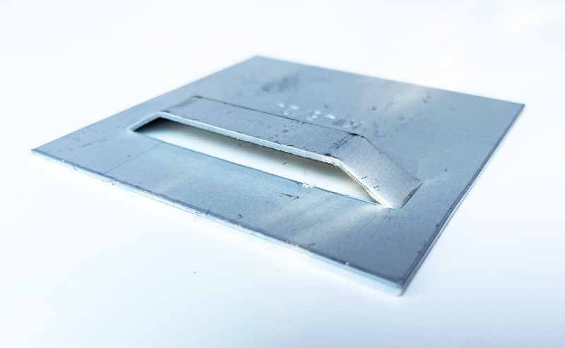 Vue du système d’attache au dos du tableau aluminium, discret et solide, permettant une fixation murale facile